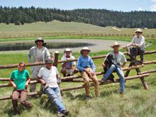 Cowboys sitting on a fence